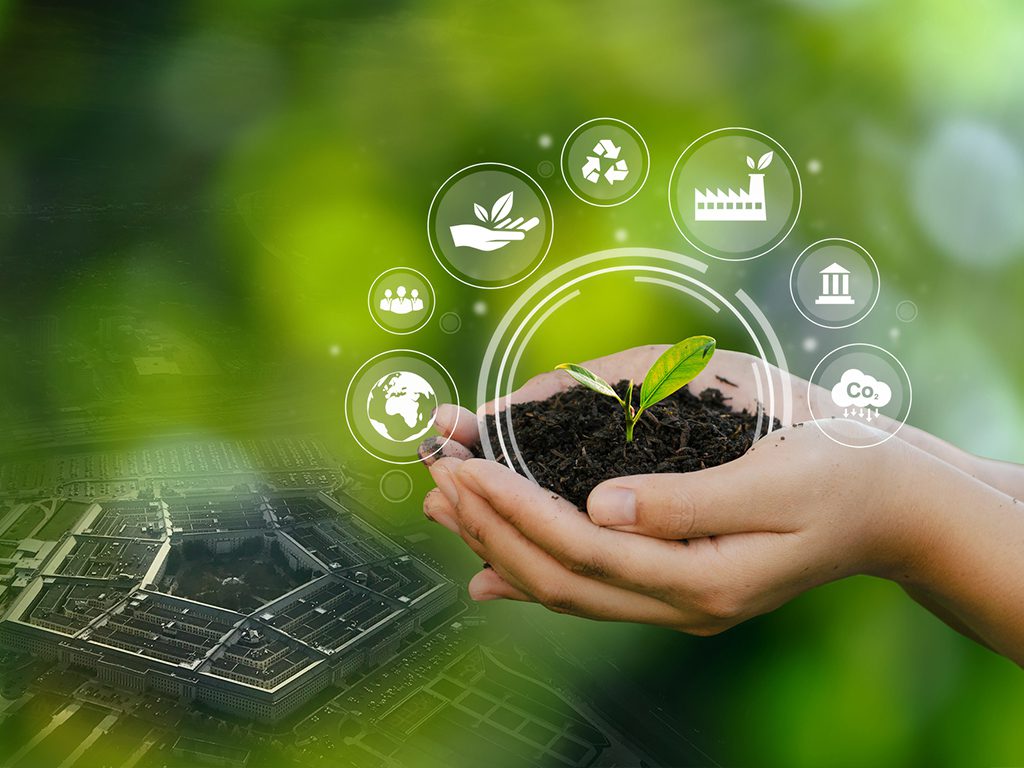 Hands holding soil with a small plant; environmental icons float above, and a blurred aerial view of a large building complex is in the background.