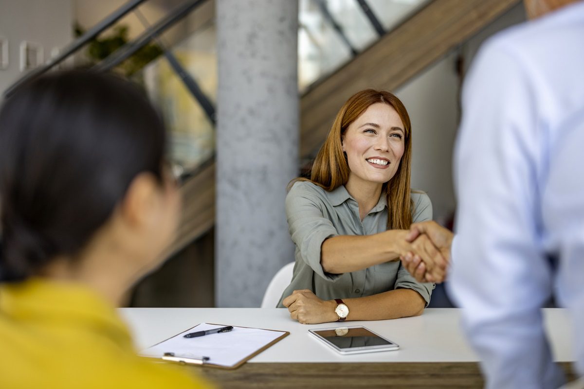 Friendly Businesswoman Shaking Hands with Colleague in Office