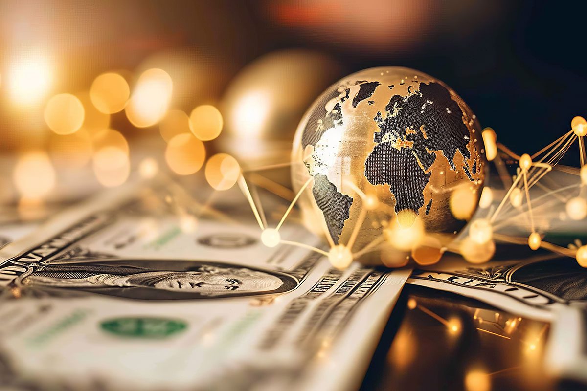 A metallic globe rests on US dollar bills, surrounded by glowing connected nodes, representing global finance and economics.