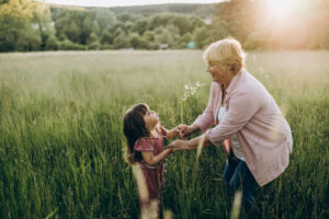 Grandmother and her little granddaughter walking in the field