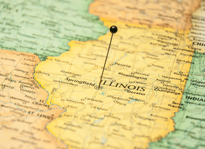 A map of Illinois with a black pin marking a central location in the state, showing nearby cities such as Springfield, Peoria, and Decatur.