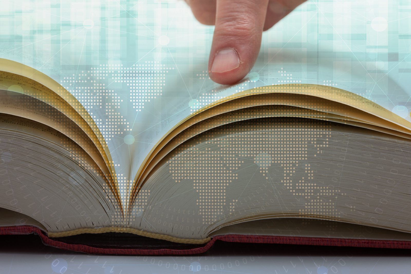 A finger points to pages of an open book with a digital world map overlayed, symbolizing global knowledge or information.