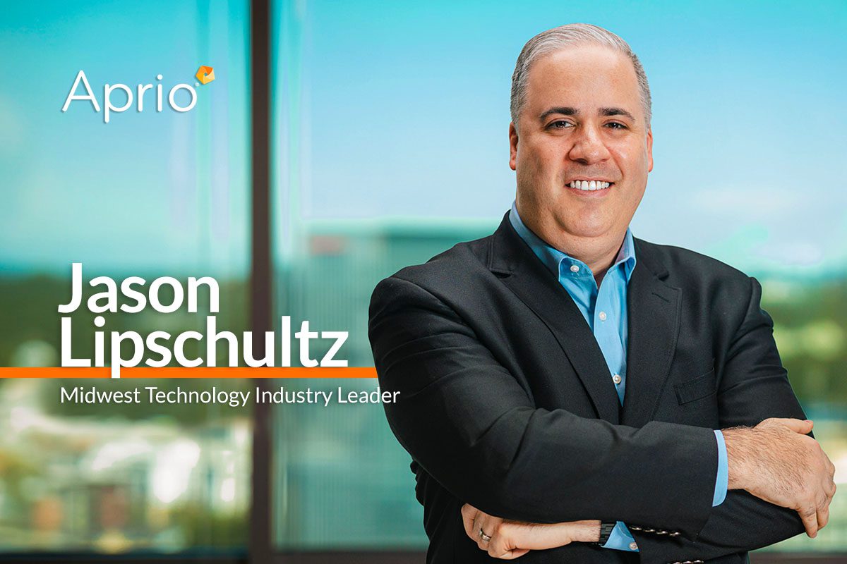 A man in a suit stands with arms crossed in front of a window. The text reads Aprio. Jason Lipschultz, Midwest Technology Industry Leader.
