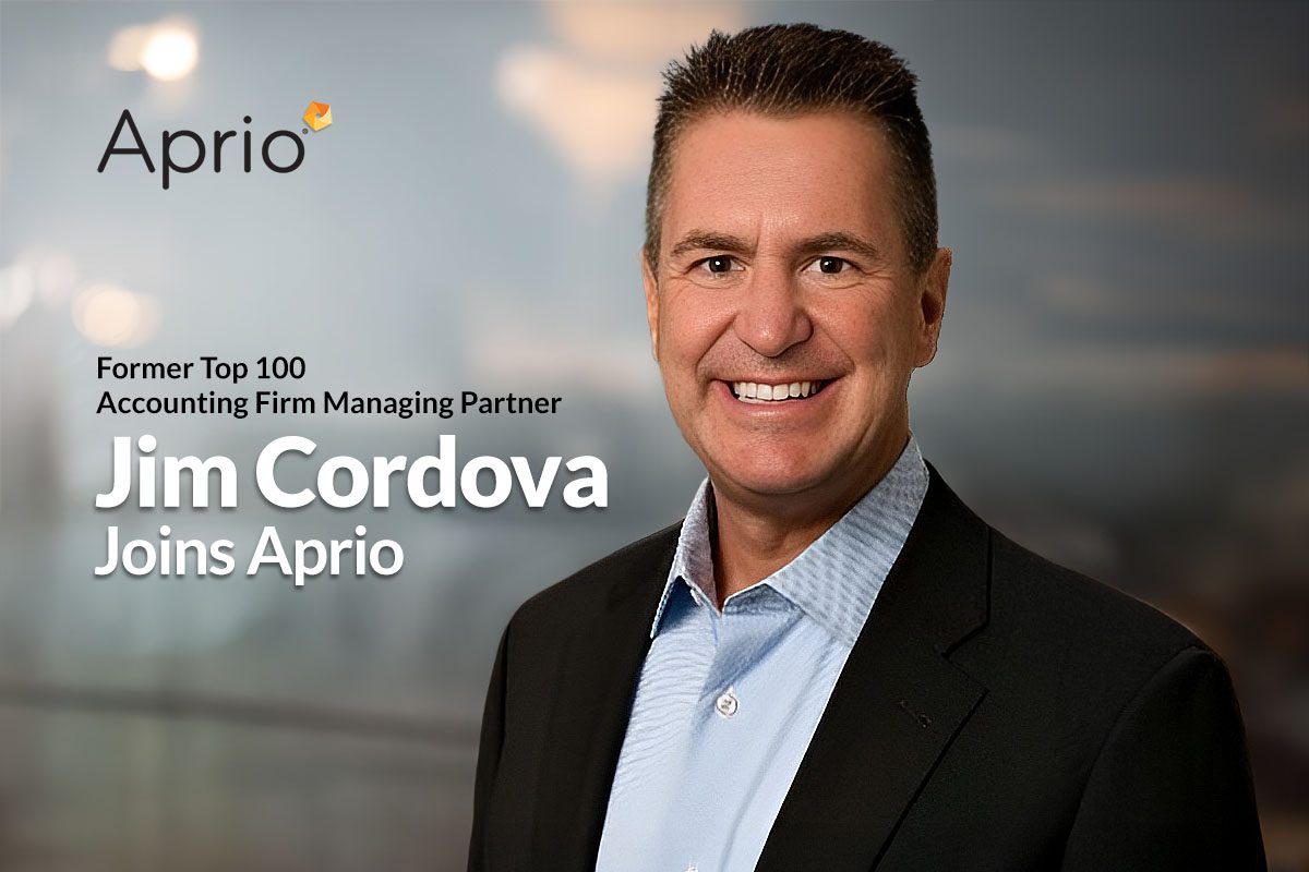 A smiling man in a suit stands in front of a blurred background; text reads: Former Top 100 Accounting Firm Managing Partner Jim Cordova Joins Aprio. Aprio logo appears in the corner.