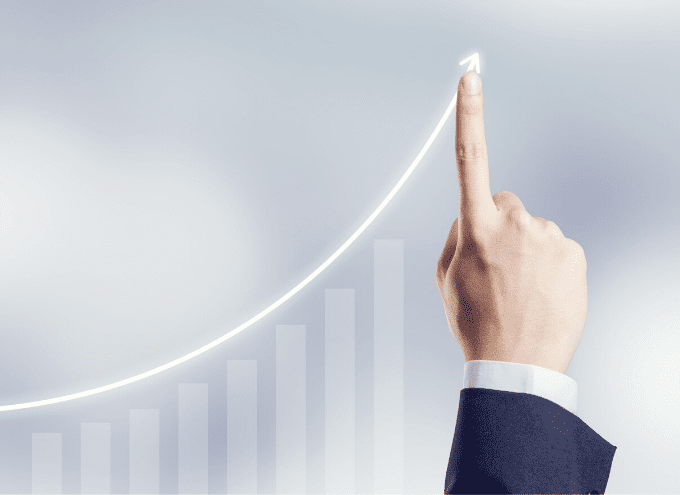 A hand in a suit points upward, touching a rising line graph with bar charts in the background, symbolizing business growth or success.