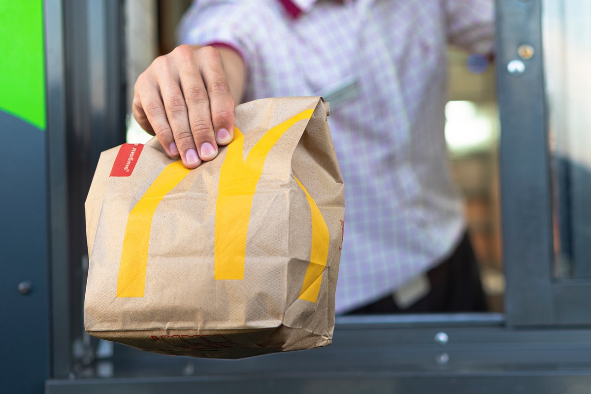 McDonald's worker holding paper bag