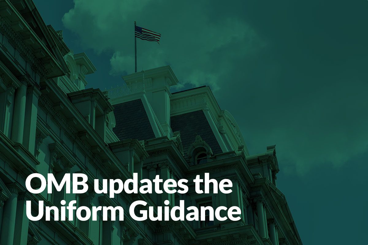 Historic government building with an American flag on top, overlaid with the text OMB updates the Uniform Guidance.
