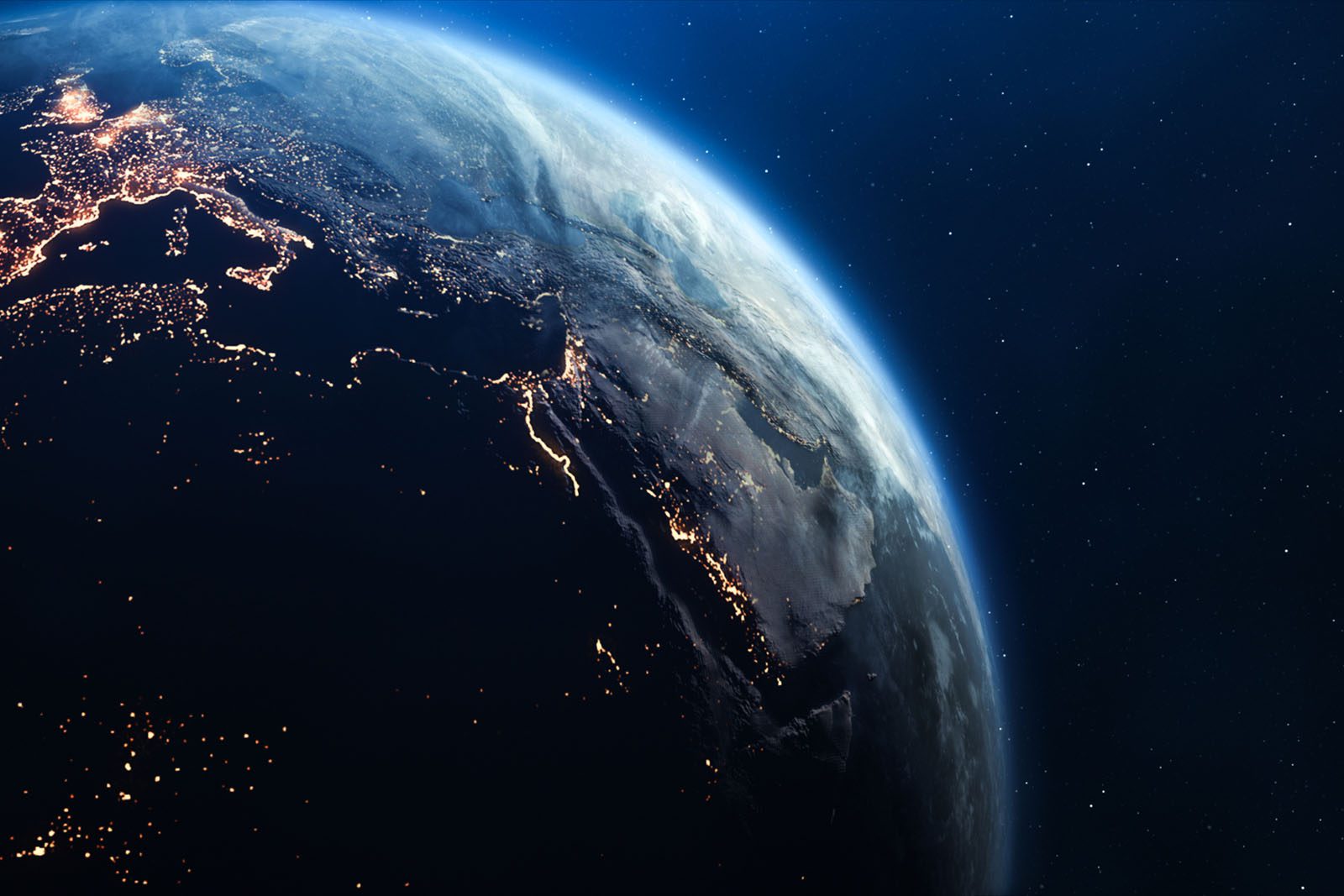 View of Earth from space showing illuminated cities and landmasses across the Middle East, with the planets curvature and atmosphere visible against a dark star-filled background.