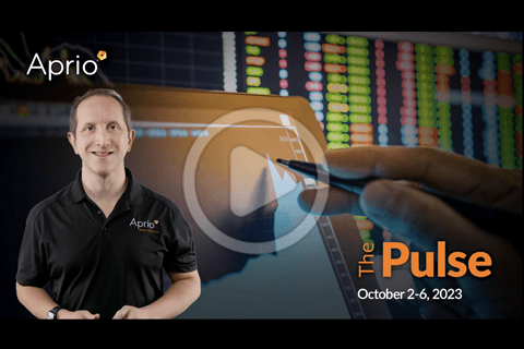 A man in an Aprio shirt stands next to graphics of financial charts and stock data, with the text “The Pulse October 2-6, 2023” displayed.