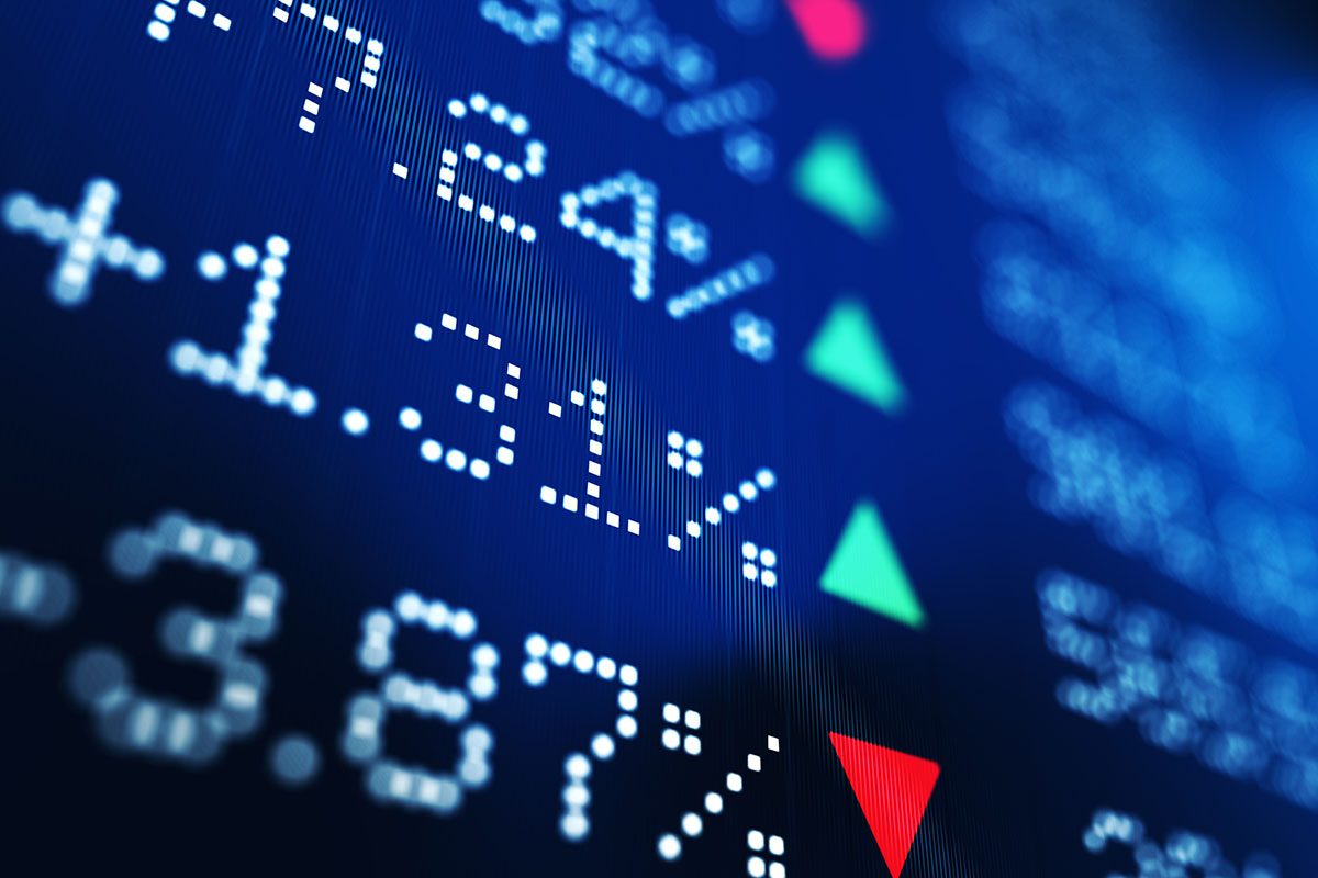 A digital display shows percentages with green upward and red downward arrows, representing stock market or financial data.