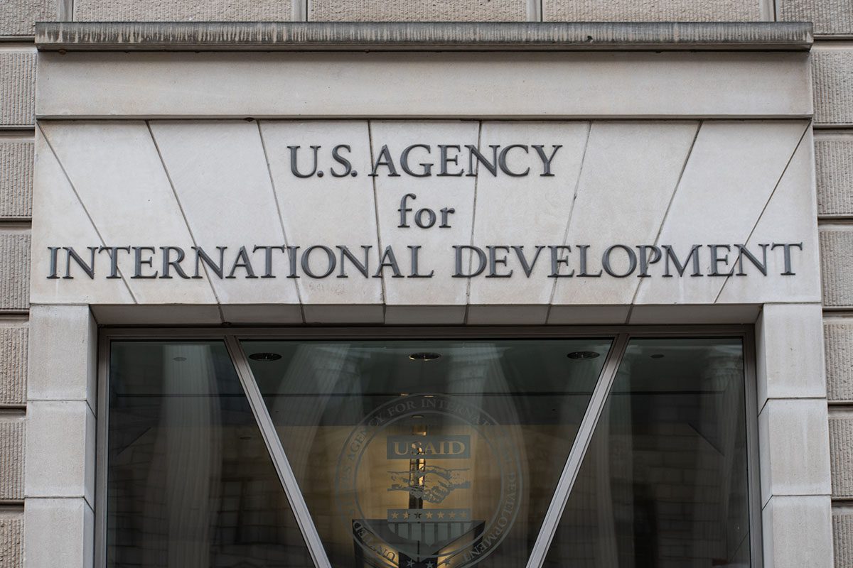 Facade of the U.S. Agency for International Development building with agency name engraved above a glass entrance.