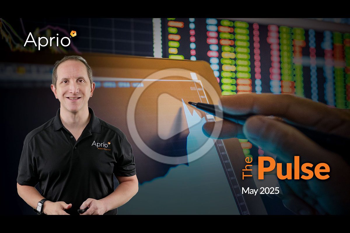 A man in an Aprio polo stands beside a screen showing financial charts. Text reads The Pulse, May 2025 with a play button overlay in the center.