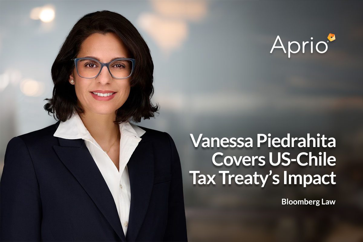 A woman in a dark suit and glasses stands in front of a blurred background next to text discussing US-Chile tax treaty impact for Bloomberg Law, with the Aprio logo in the top right corner.