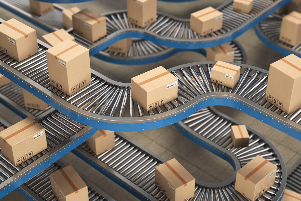 Several sealed cardboard boxes move along curving blue conveyor belts in a warehouse or distribution center setting.