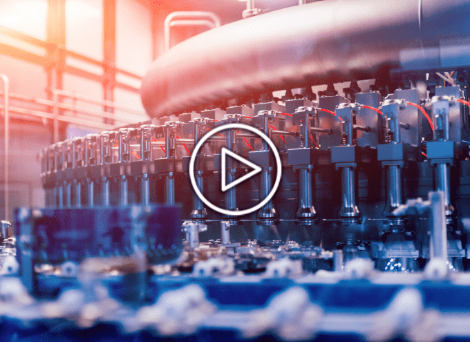 A modern automated bottling machine in a factory, with multiple filling nozzles and conveyor system, under bright industrial lighting.