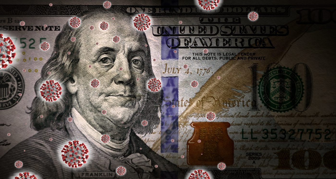 A close-up of a US $100 bill overlaid with illustrated coronavirus particles representing the impact of COVID-19 on the economy.