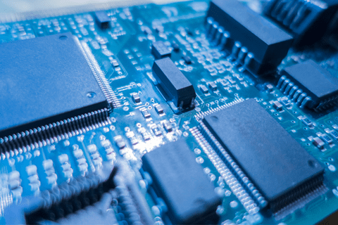 Close-up view of a blue printed circuit board with multiple integrated circuits and electronic components.