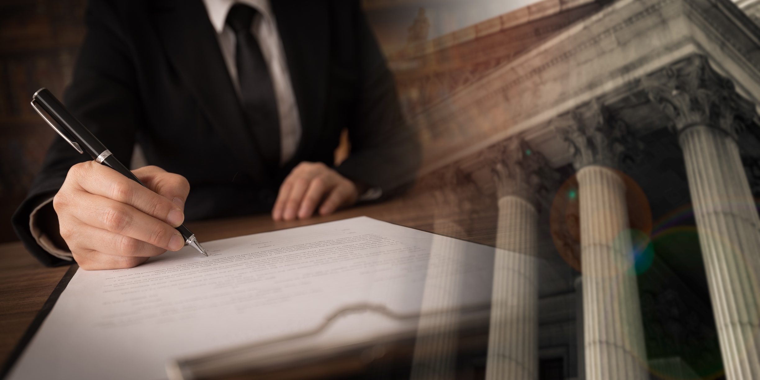 A person in a suit signs a document at a desk, overlaid with an image of courthouse columns.