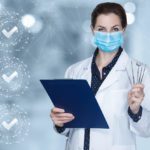 A doctor wearing a mask and lab coat holds a clipboard and dental tools, standing in front of a background with checkmark icons.