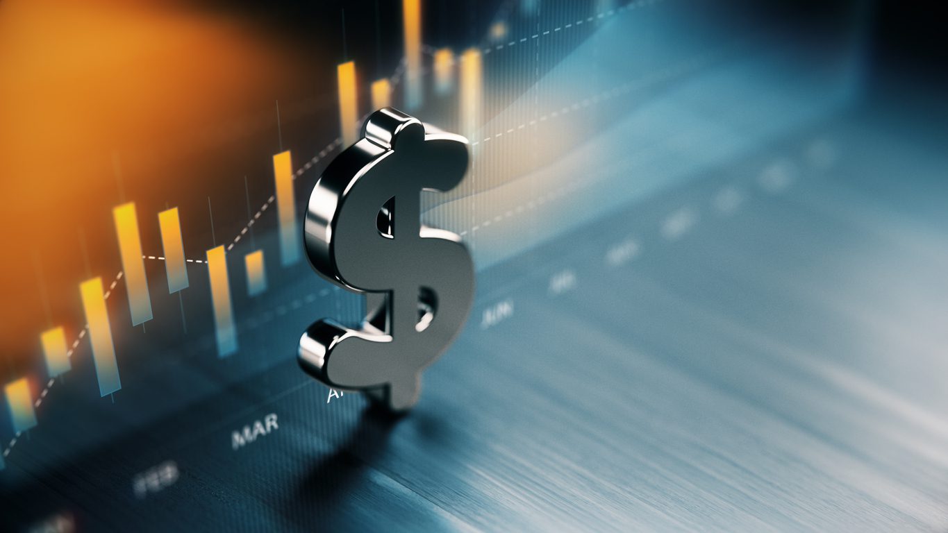 A metallic dollar sign stands in front of a blurred financial chart with rising orange and blue bars and a trend line.