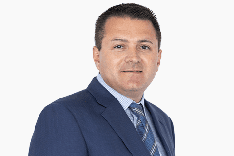 Man in a blue suit and striped tie, posing for a professional headshot against a white background.