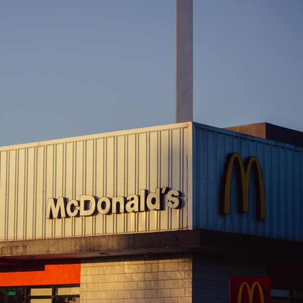 Exterior shot of a McDonald's building with white branded text and gold M logo