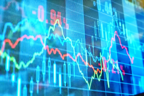 Close-up of a digital display showing multiple colorful financial graphs and fluctuating numerical data, representing stock market or trading activity.