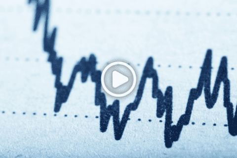 Close-up of a jagged black line graph on a light blue background, showing fluctuations. A play button overlay is centered on the image, indicating it is a video thumbnail.