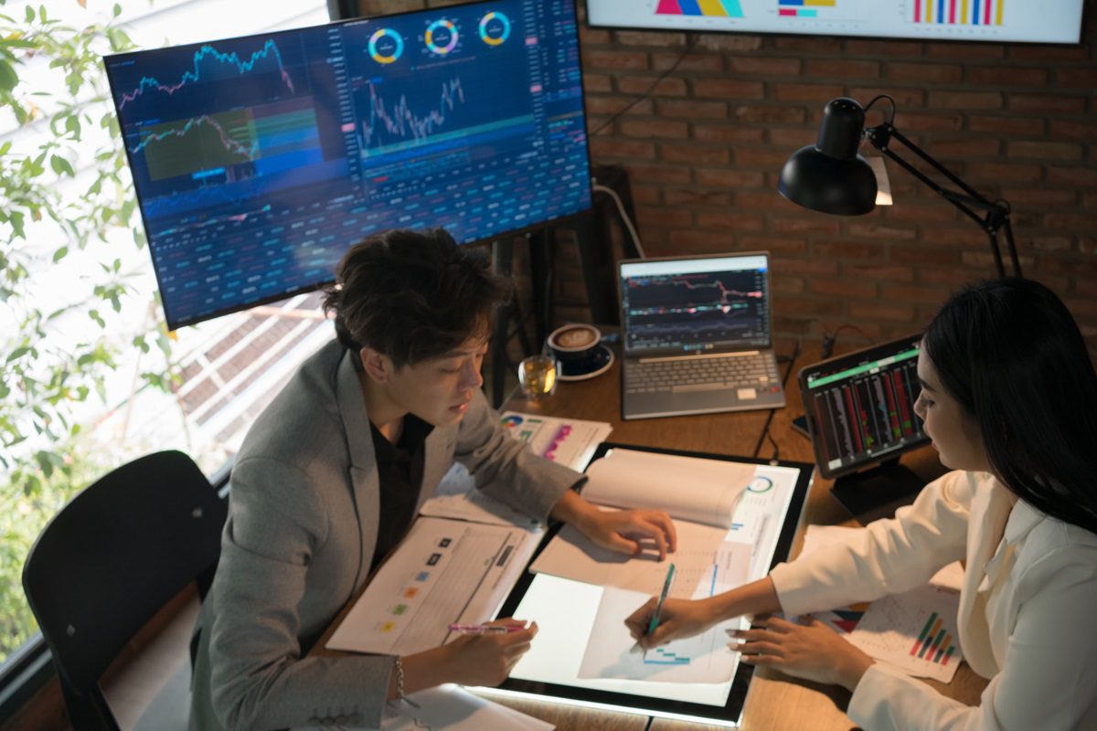 Shot of two young businesspeople working ,Two business man and women discussing over digital tablet at desk in office . Success, Teamwork,Technology, Working,