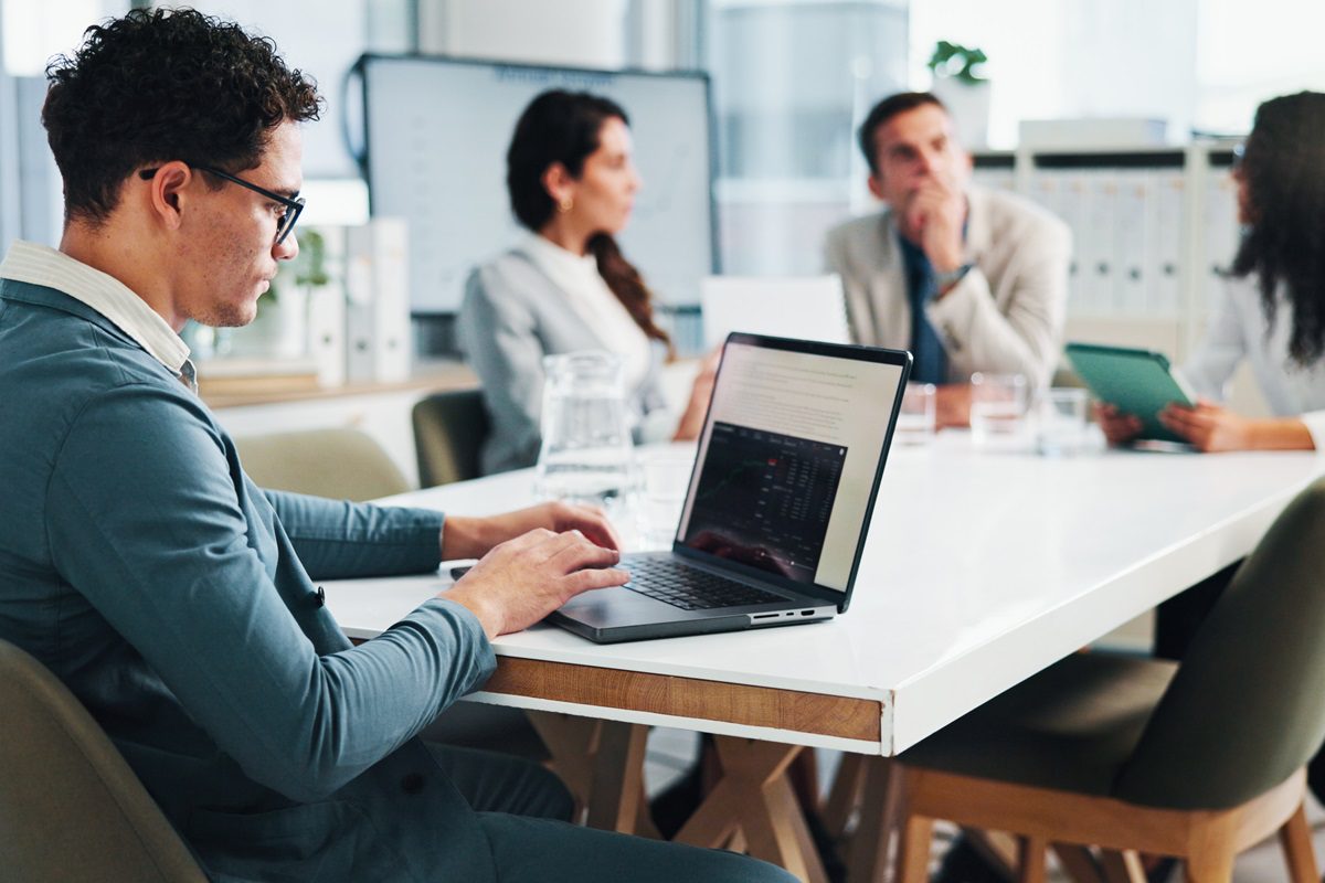 Office, businessman and screen with laptop in meeting, about us and research for stock market. Boardroom, male person and trader with digital for financial performance, risk management and corporate