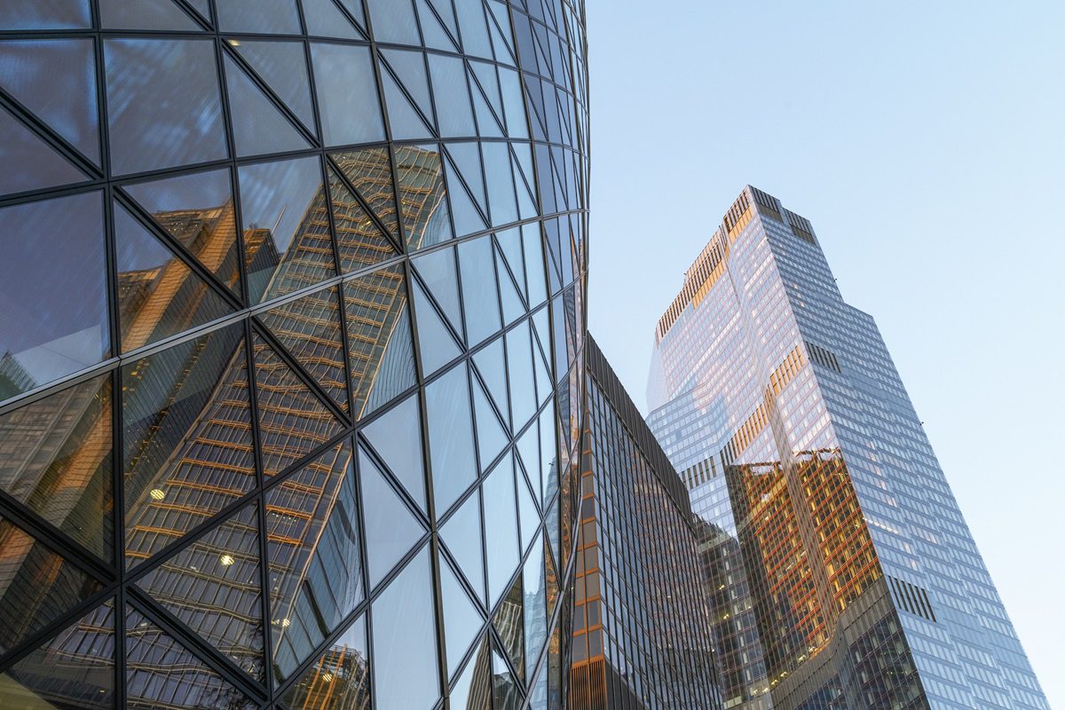 UK, London, low angle view of modern glass and steel built office towers at sunrise