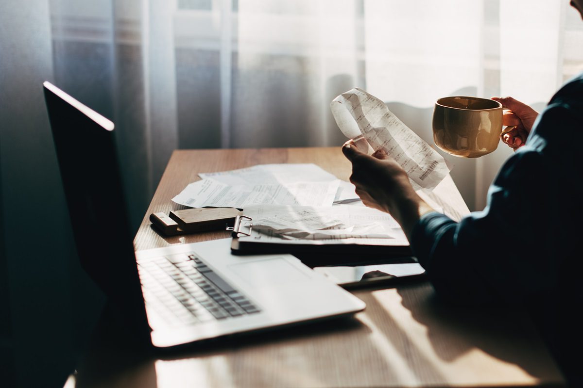 Close up Business woman using calculator and laptop for do math finance on wooden desk in office and business working background, tax, accounting, statistics and analytic research concept