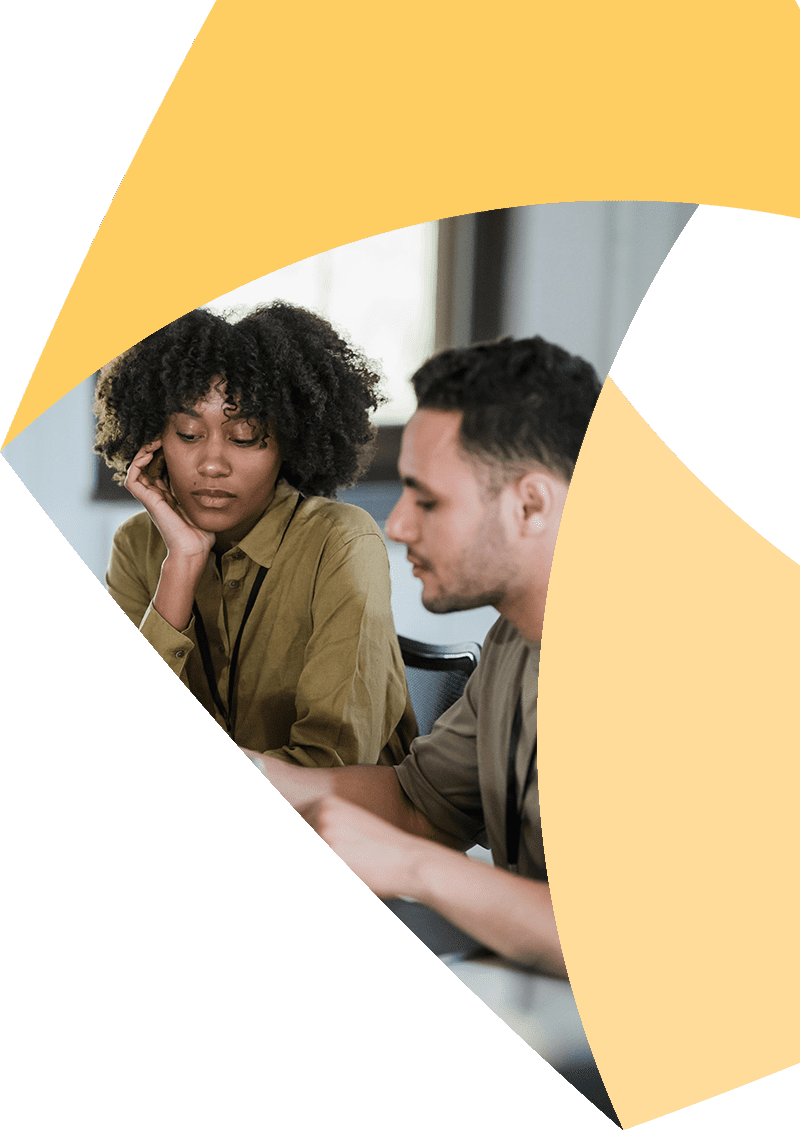 In a corner of the Aprio pinwheel logo, a man and woman sit together and look at something on the table