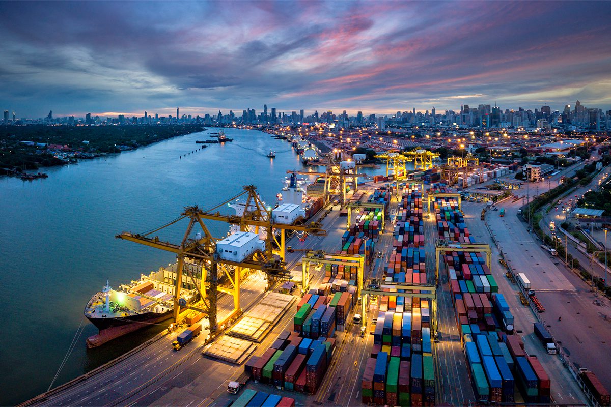 Aeries view of an international port with a crane loading containers in an import export business.