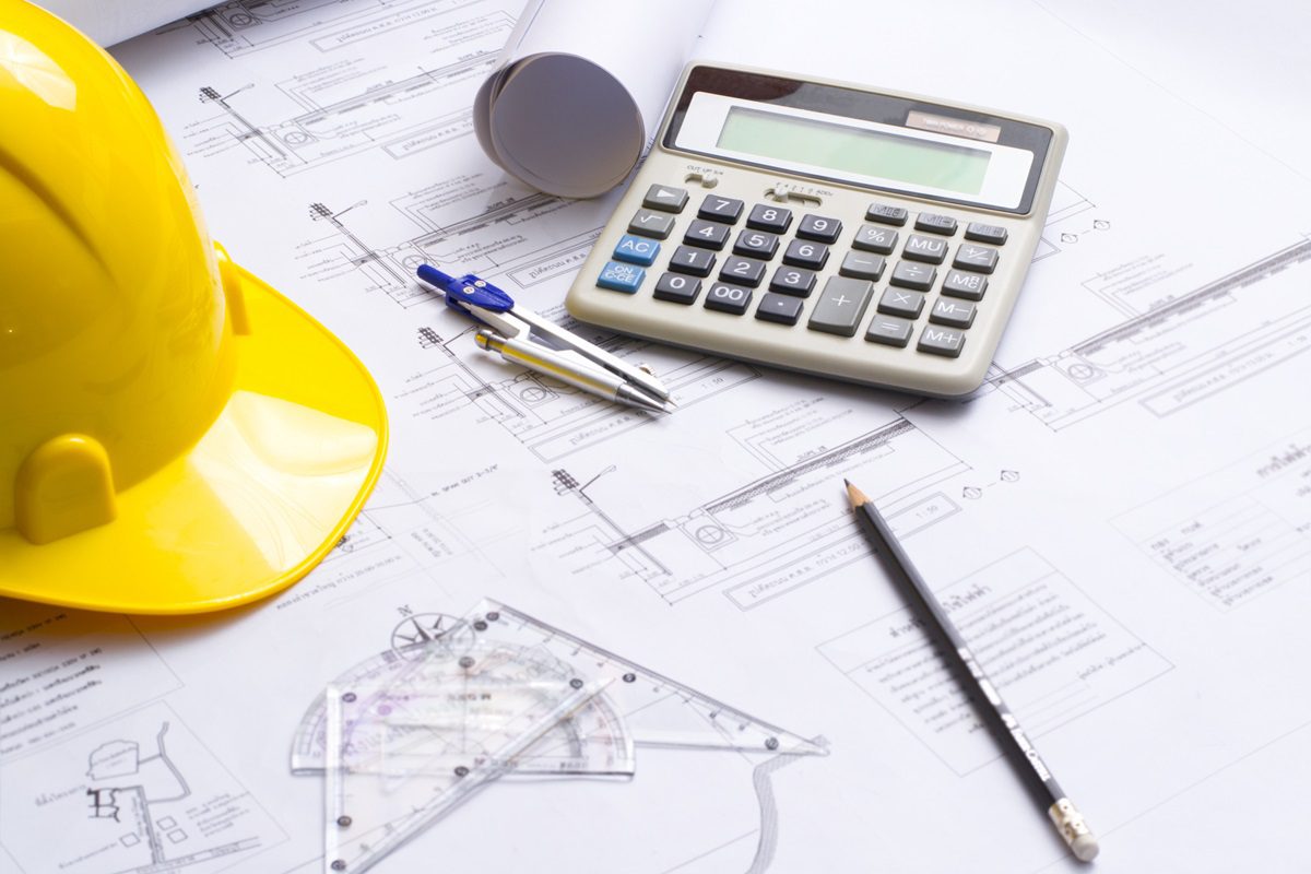 Construction helmet and heap of project drawings. Architectural design and construction background.