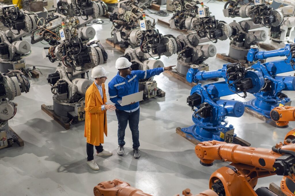 Engineer factory industry wearing safety uniform work and checking system of the welding robots for welding steel electrical