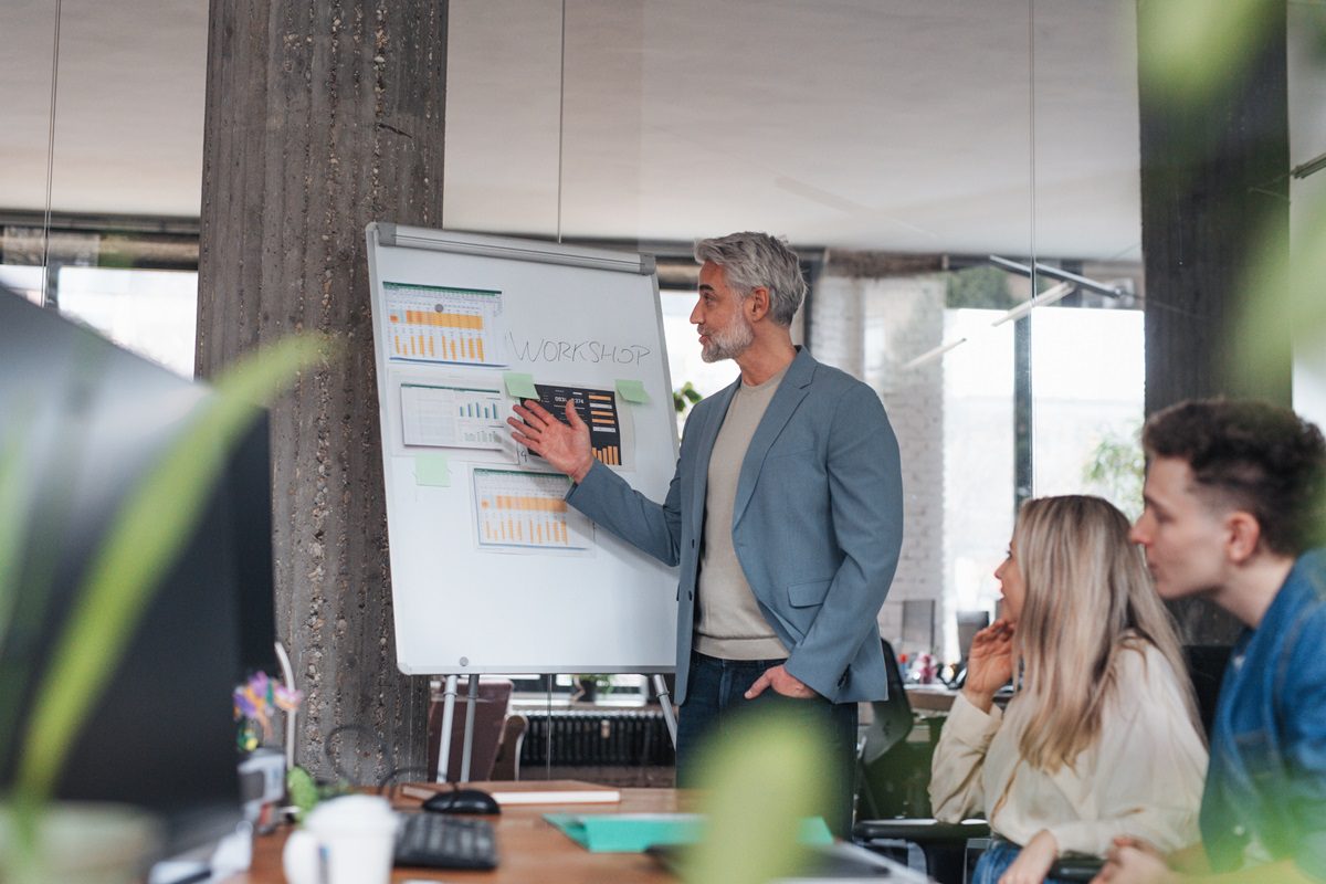 Businessman giving a presentation in a business meeting. Young colleagues and manager having casual discussion during meeting, workshop in office.