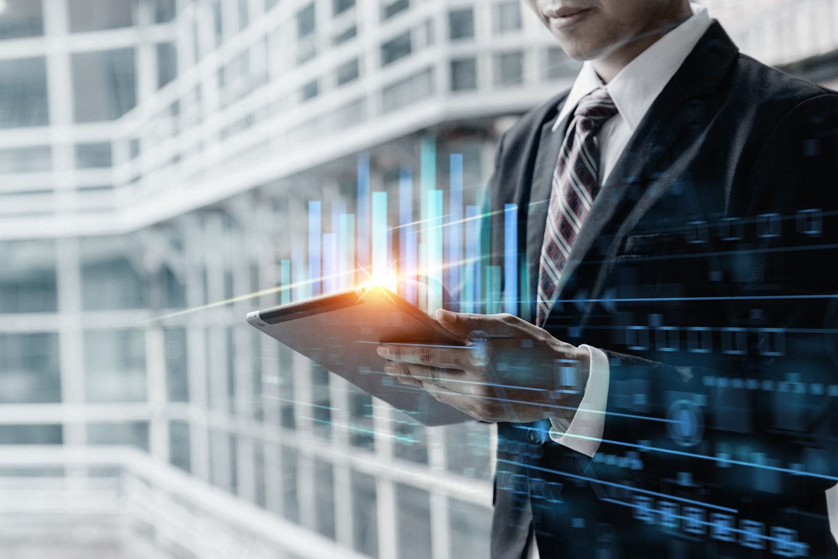 Businessman using tablet computer for analysis chart data of stock market, business and finance concept.