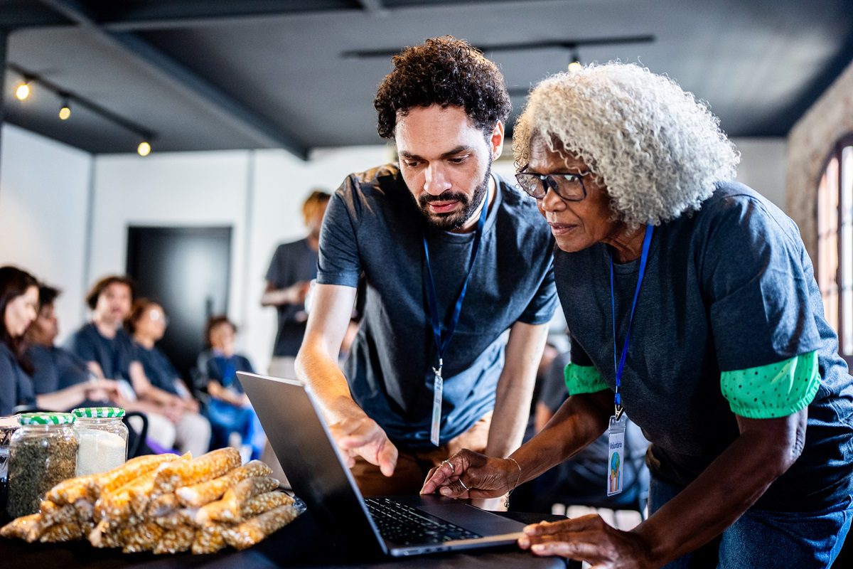 Volunteers using laptop during community outreach