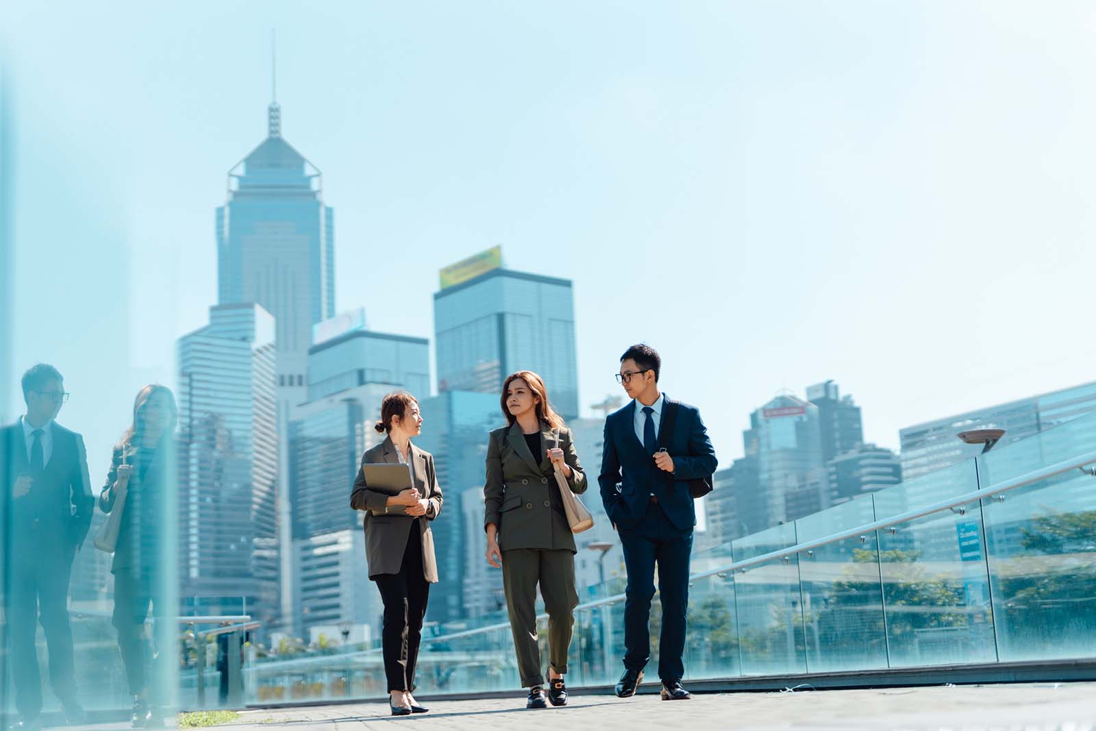 Business people talking and walking against urban skyscraper