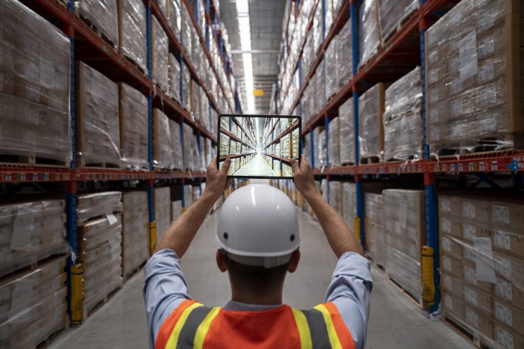 Foreman with tablet taking photos of the warehouse.