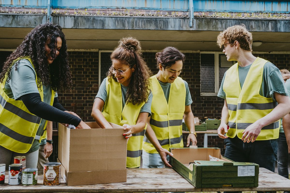 Smiling male and female friends working at table in non-profit organization