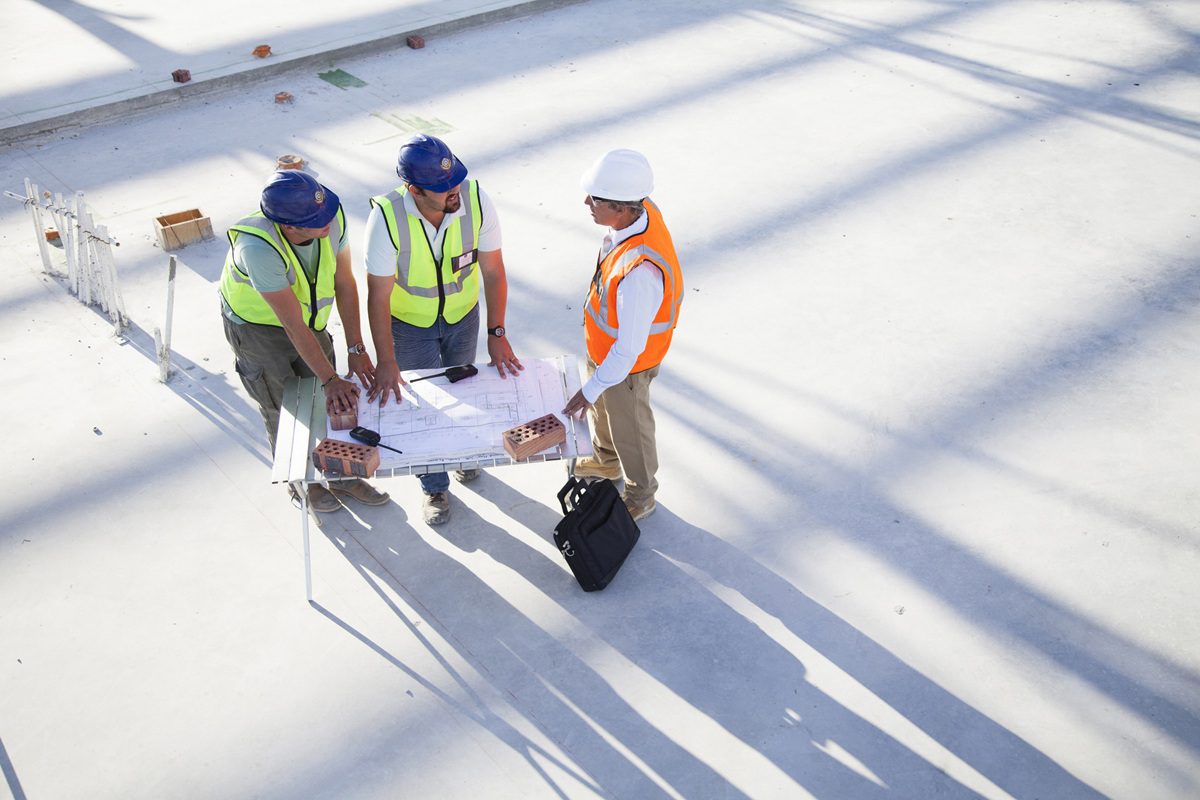 Architects reading blueprints at construction site