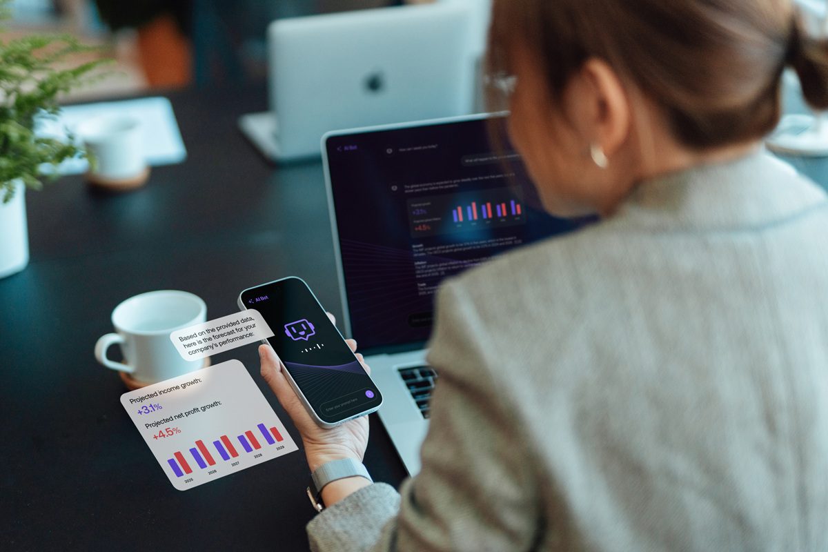 Over the shoulder view of businesswoman talking to virtual assistance on smartphone, using AI chatbot to generate information and analyse data. Open AI technology. Online robot system. Business and technology.