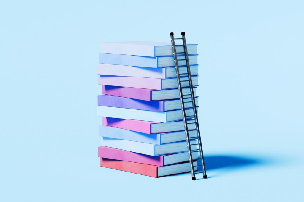 Abstract educational concept featuring a vertical stack of blank books in bold shades of blue, red, and purple, set against a clean blue background. A slender ladder extends from the ground to the top of the stack, symbolizing ambition, growth, and the journey of knowledge. The colorful, minimal design is ideal for illustrating academic achievement, career progression, training, and professional development in educational, corporate, or motivational materials.