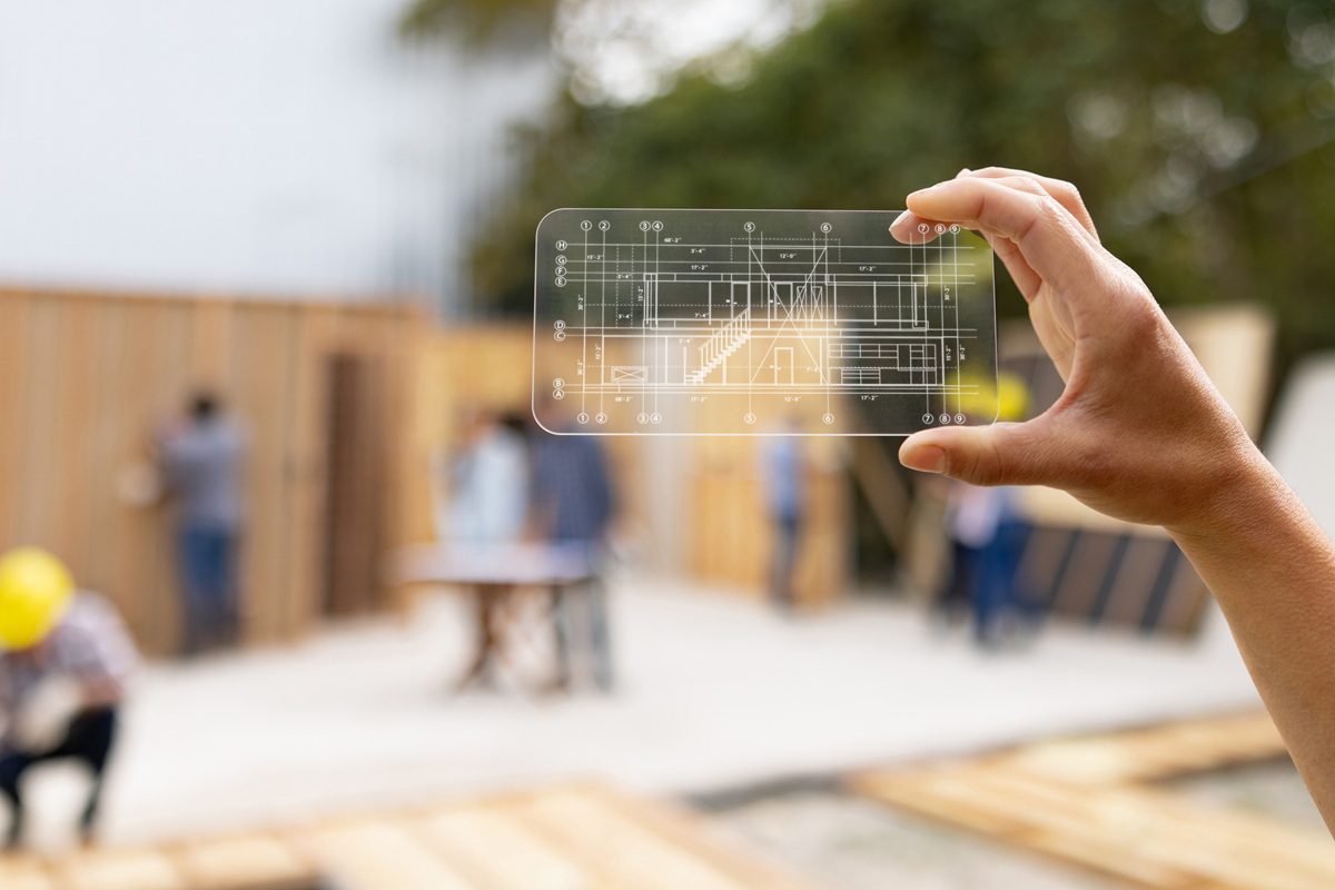 Close-up on an architect at a construction site looking at a blueprint using an interactive screen