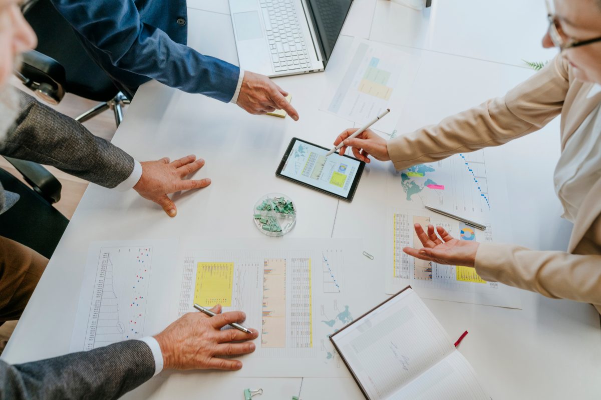 Business team discussing charts and graphs at office desk top view