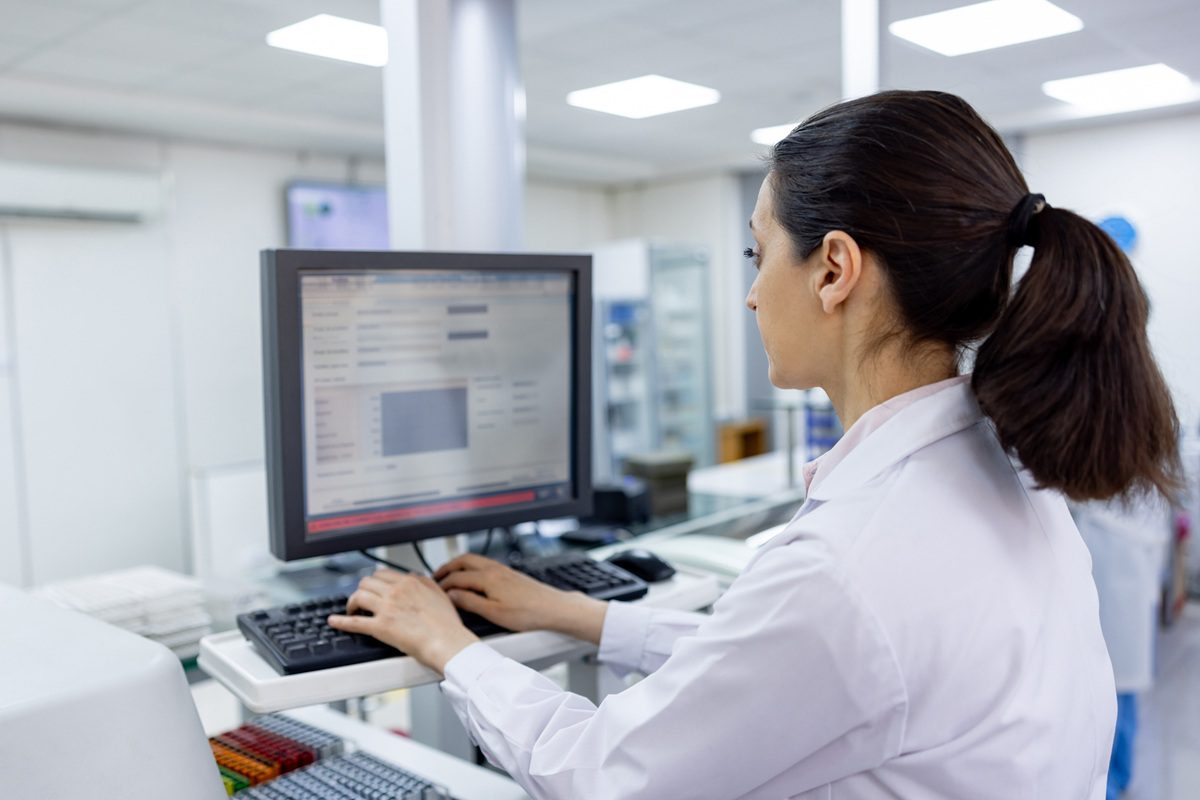 Latin American female scientist working at a laboratory doing research using a computer - STEM concepts