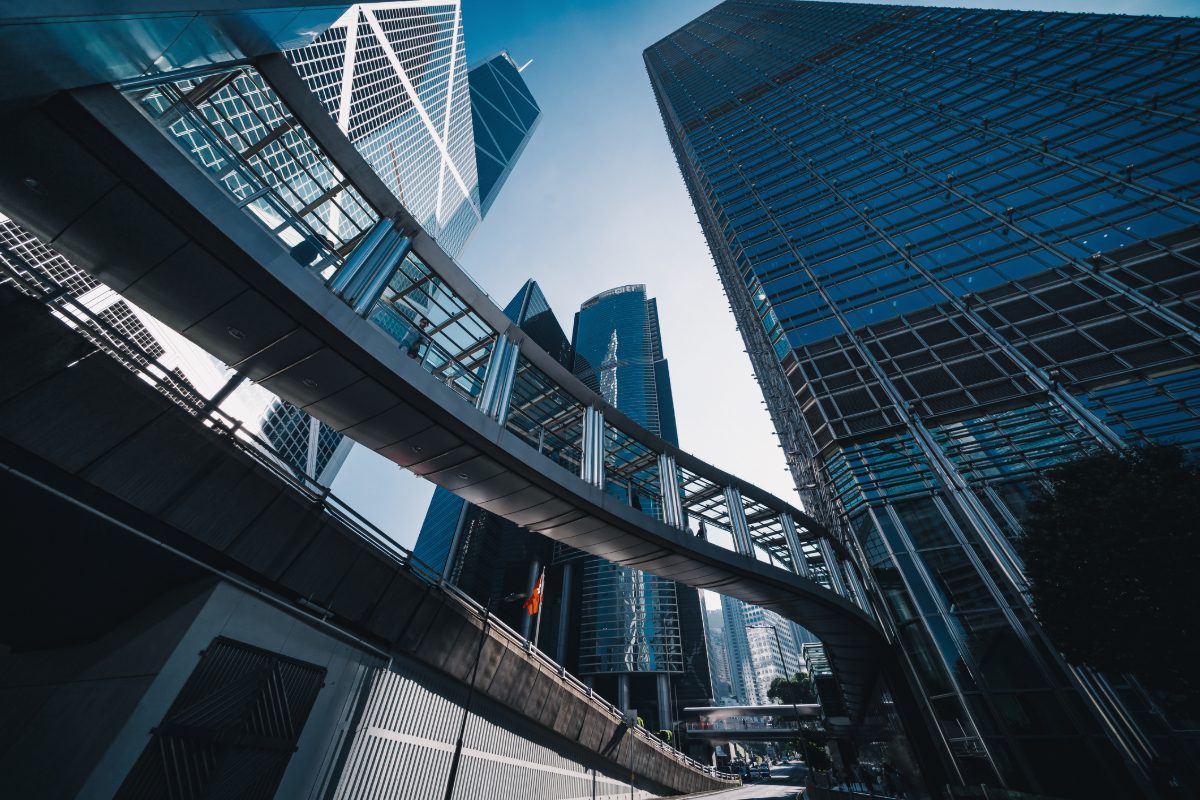 Low angle view of the financial and business hub of Central, Hong Kong with contemporary financial and corporate skyscrapers with unique architectural designs against blue sky. Skyline of Hong Kong financial district. Business, finance and economy themes