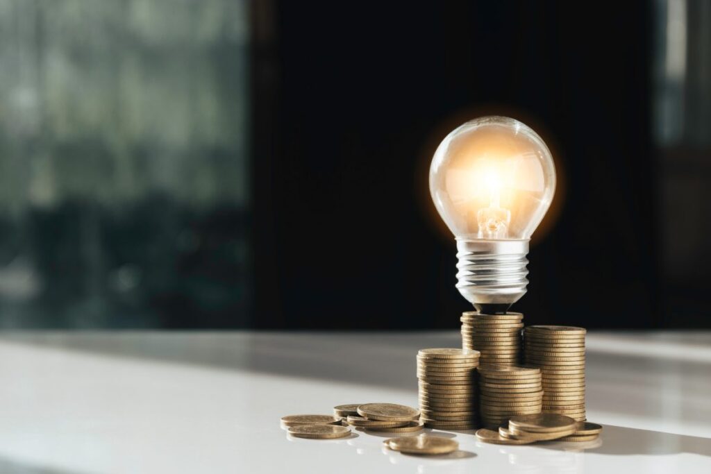 Coins and light bulb put on the table for saving money,energy concept.